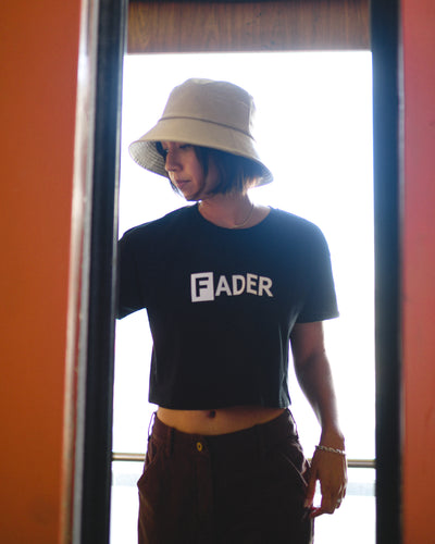 woman wearing black crop tee with the FADER logo